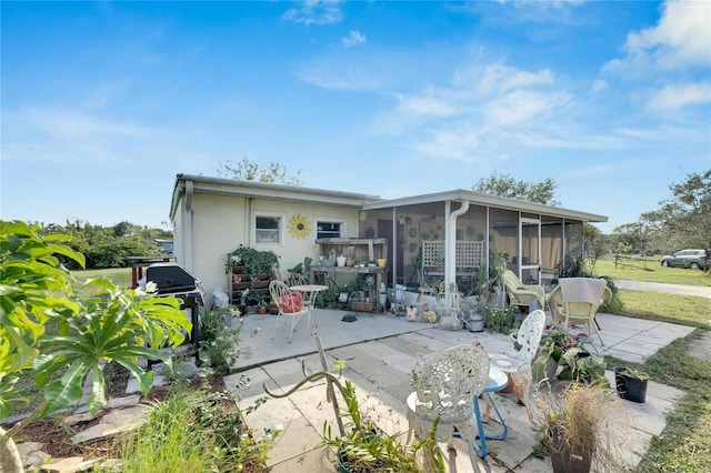 rear view of property with a sunroom and a patio area