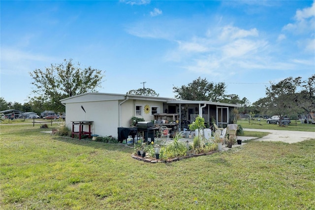 back of property featuring a sunroom and a yard