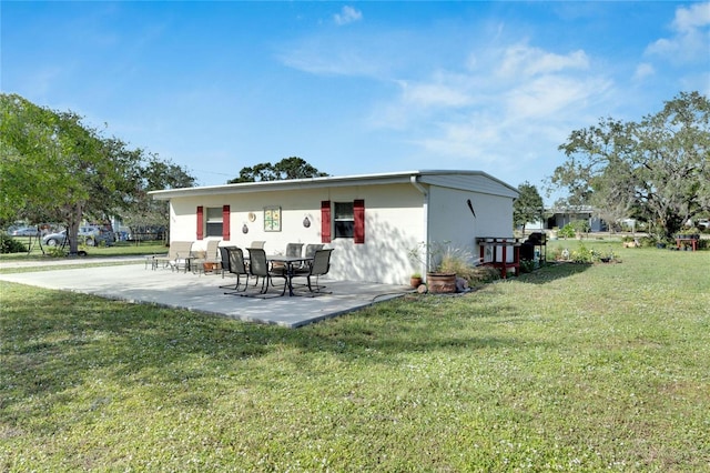 rear view of property featuring a lawn and a patio