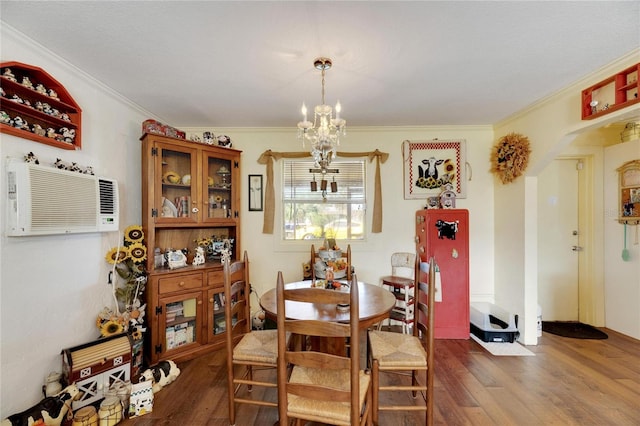 dining space featuring a chandelier, crown molding, dark wood-type flooring, and a wall unit AC