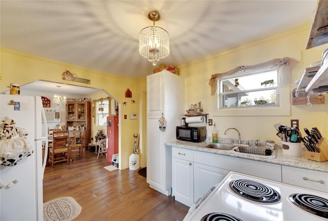 kitchen with white appliances, dark hardwood / wood-style floors, white cabinetry, and hanging light fixtures