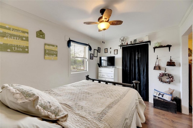 bedroom featuring wood-type flooring, ceiling fan, and crown molding