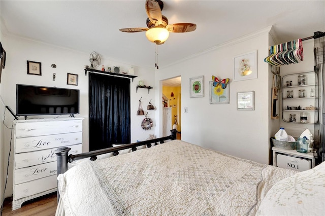 bedroom with hardwood / wood-style flooring, ceiling fan, and ornamental molding