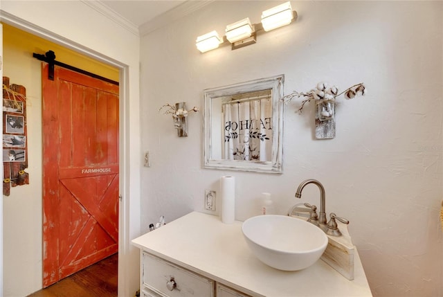 bathroom with wood-type flooring, vanity, and crown molding