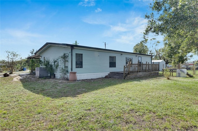 rear view of house with a yard and a deck