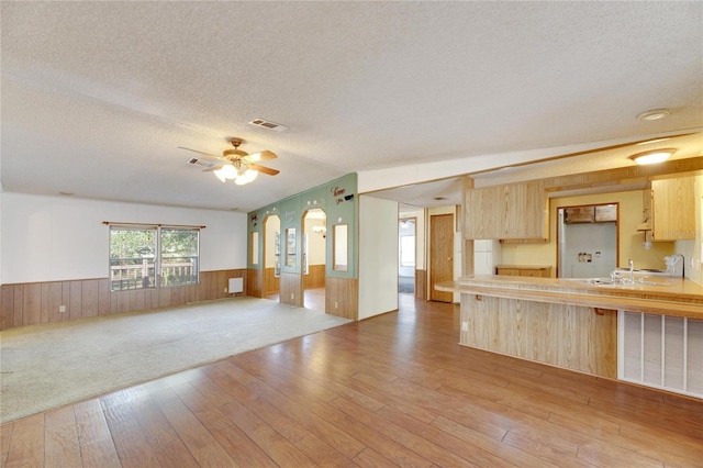 kitchen featuring hardwood / wood-style floors, a textured ceiling, and light brown cabinetry