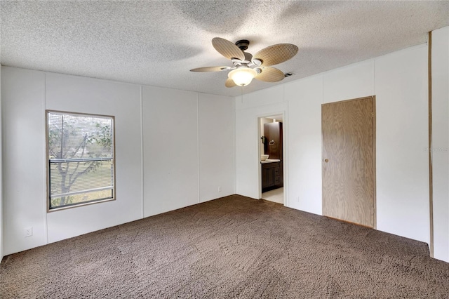 empty room featuring carpet flooring, ceiling fan, and a textured ceiling