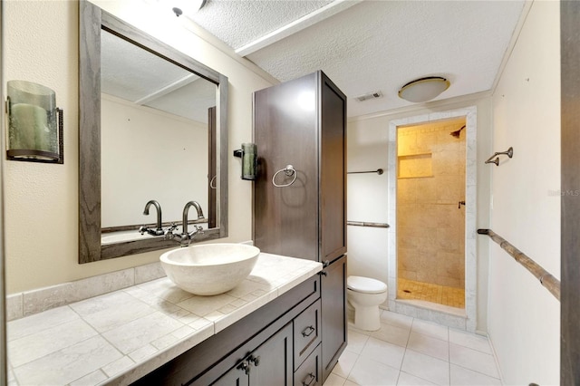 bathroom featuring toilet, a tile shower, a textured ceiling, and tile patterned floors