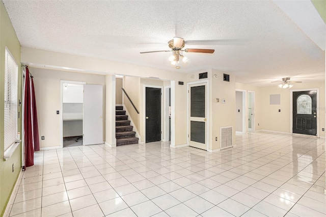 unfurnished room featuring ceiling fan, light tile patterned floors, and a textured ceiling