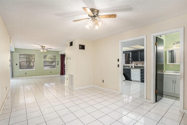 tiled empty room with ceiling fan and a textured ceiling