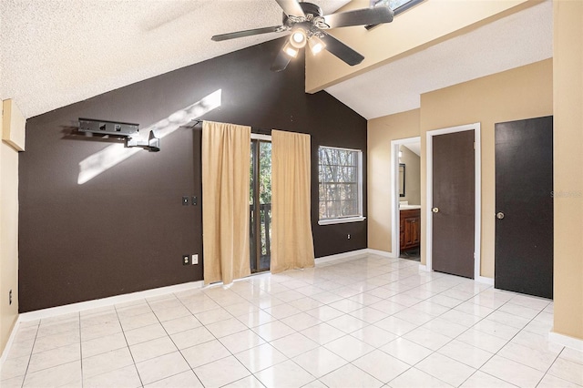 empty room featuring lofted ceiling with beams, ceiling fan, light tile patterned floors, and a textured ceiling