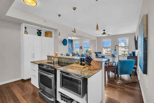 226 5th Ave N Unit 706, Saint Petersburg, FL 33701 - kitchen with stainless steel appliances, open floor plan, dark wood finished floors, light stone counters, and hanging light fixtures