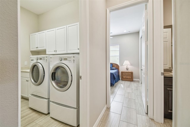 laundry area featuring cabinets and washing machine and clothes dryer