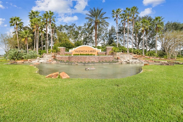 community sign with a yard and a water view