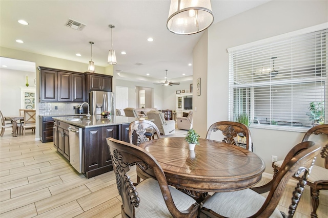 dining space featuring ceiling fan and sink