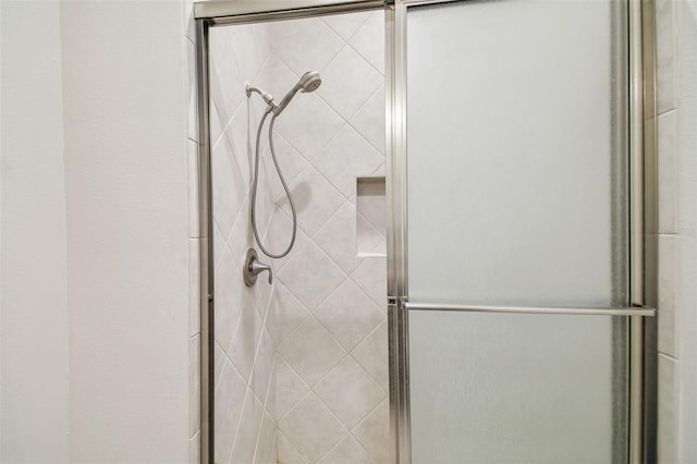 bathroom with a shower with door