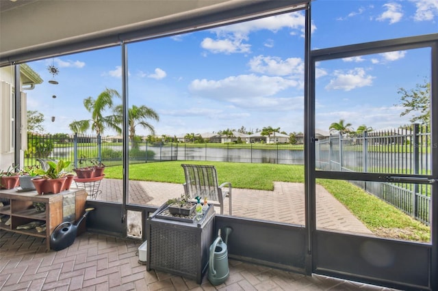 sunroom featuring a water view