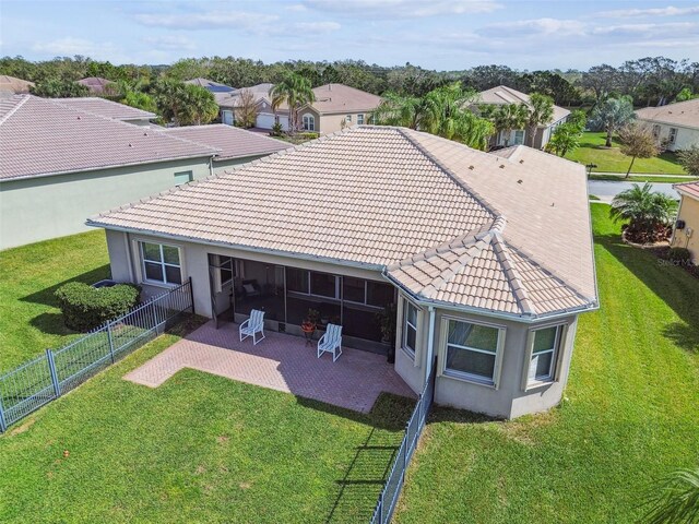 rear view of house featuring a lawn and a patio