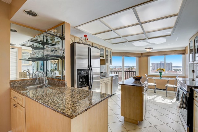 1651 Sand Key Estates Ct Unit 52, Clearwater, FL 33767 - kitchen with stainless steel appliances, a sink, a center island, glass insert cabinets, and light tile patterned floors
