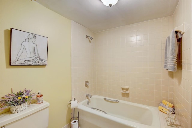 bathroom featuring toilet and tiled shower / bath