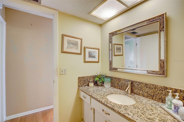 bathroom featuring hardwood / wood-style floors, vanity, and a skylight