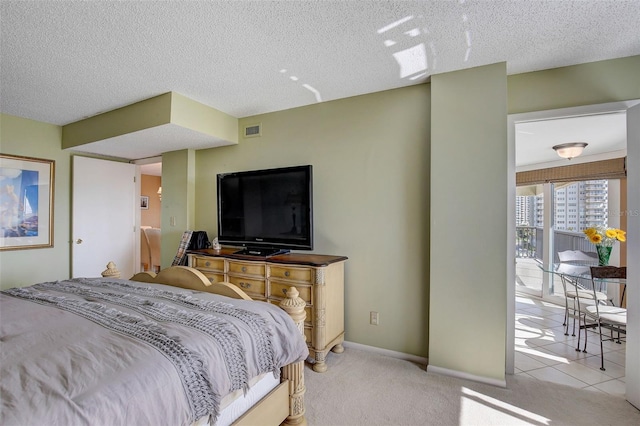 bedroom featuring light carpet and a textured ceiling