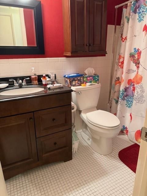 bathroom featuring toilet, tile patterned flooring, tasteful backsplash, vanity, and walk in shower