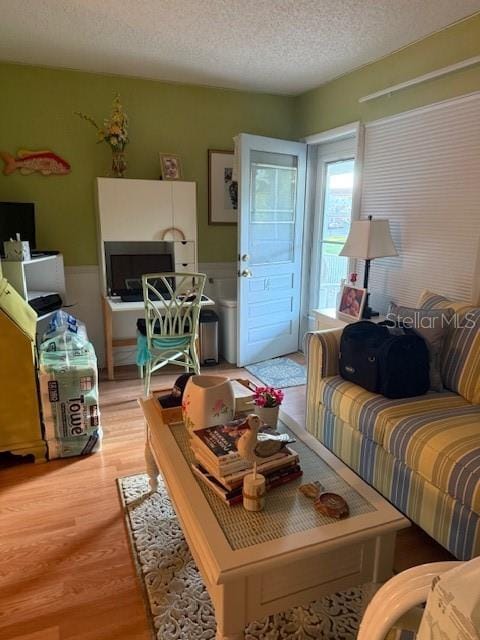 2100 World Parkway Blvd Unit 14, Clearwater, FL 33763 - living area featuring a textured ceiling, light wood-style floors, and a wainscoted wall