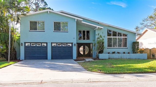 view of front of home with a garage, french doors, and a front lawn