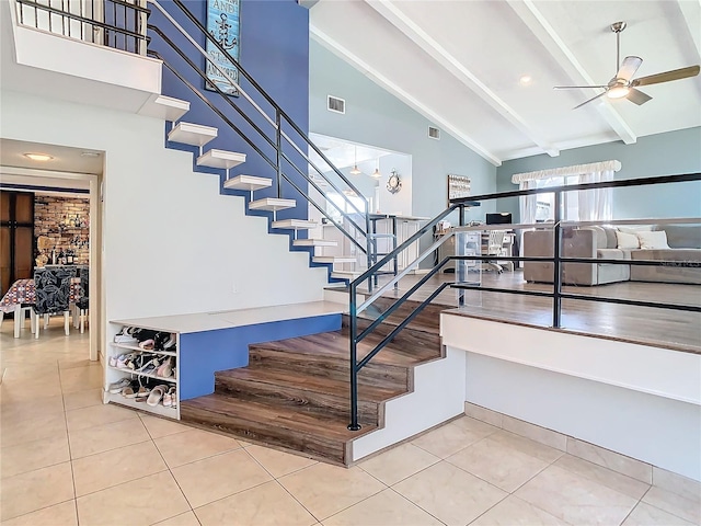 stairway with beamed ceiling, tile patterned floors, high vaulted ceiling, and ceiling fan