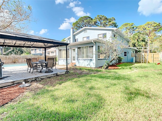 back of property with a gazebo, a lawn, and a sunroom