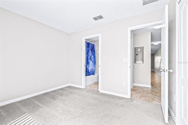 unfurnished bedroom featuring electric panel and light carpet