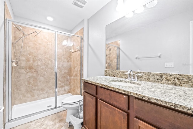 bathroom with a shower with shower door, vanity, toilet, and tile patterned flooring