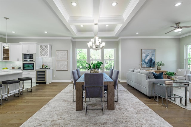 dining area featuring ornamental molding, ceiling fan with notable chandelier, dark hardwood / wood-style floors, and beverage cooler