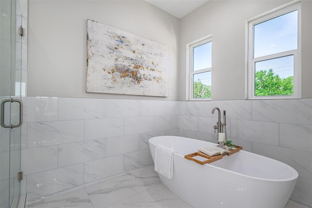 3845 Seena Manor Ct, Tampa, FL 33618 - full bathroom with tile walls, marble look tile flooring, a stall shower, a freestanding bath, and wainscoting