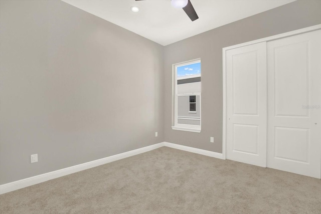 unfurnished bedroom with light colored carpet, ceiling fan, and a closet