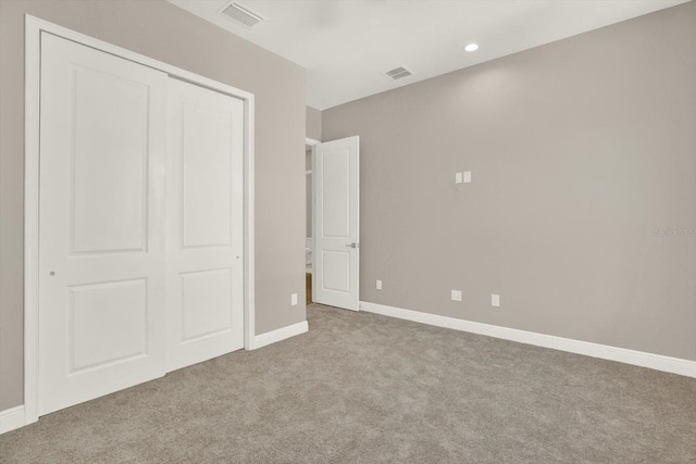 unfurnished bedroom featuring a closet and light carpet