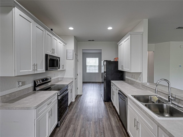 232 Samantha Ave, Auburndale, FL 33823 - kitchen featuring stainless steel appliances, a sink, white cabinets, dark wood-style flooring, and light countertops