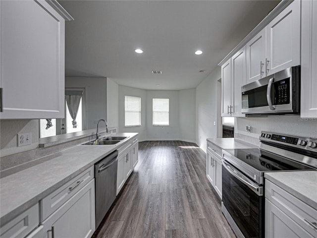232 Samantha Ave, Auburndale, FL 33823 - kitchen with appliances with stainless steel finishes, a sink, dark wood finished floors, light countertops, and white cabinets