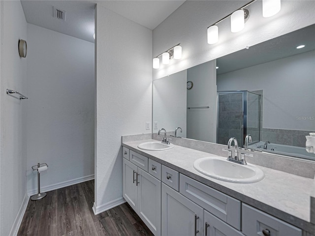 232 Samantha Ave, Auburndale, FL 33823 - bathroom with double vanity, a shower stall, wood finished floors, a tub to relax in, and baseboards