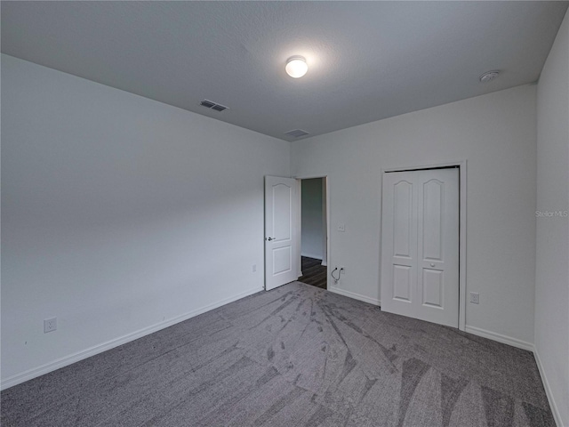 232 Samantha Ave, Auburndale, FL 33823 - unfurnished bedroom with dark colored carpet, baseboards, and a closet