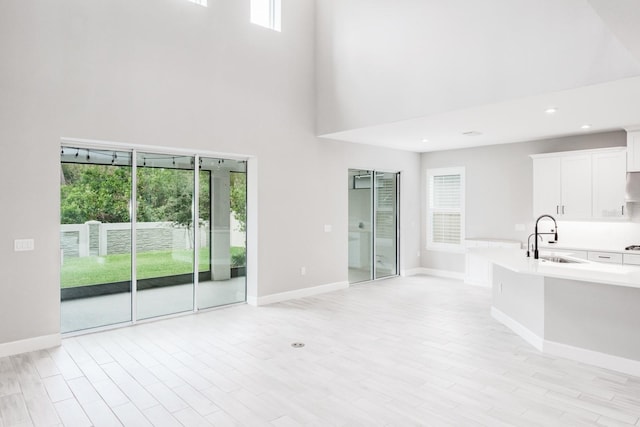 interior space with a high ceiling, sink, and a wealth of natural light