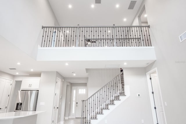 stairs featuring a towering ceiling