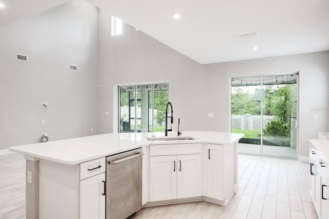 kitchen with dishwasher, sink, an island with sink, and white cabinets