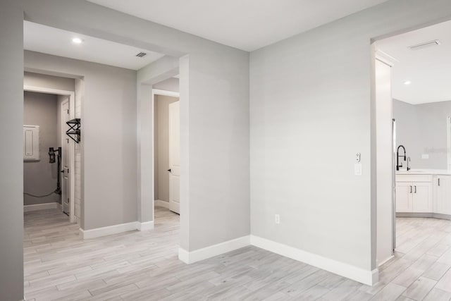 empty room with sink and light hardwood / wood-style floors