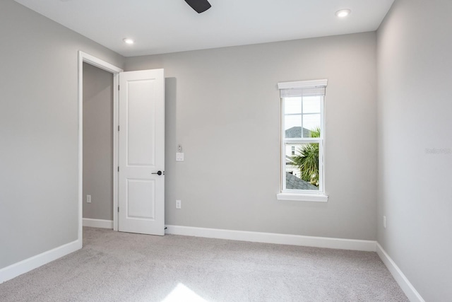 unfurnished room featuring light colored carpet and ceiling fan