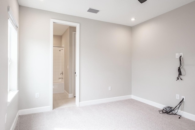 unfurnished room featuring light carpet