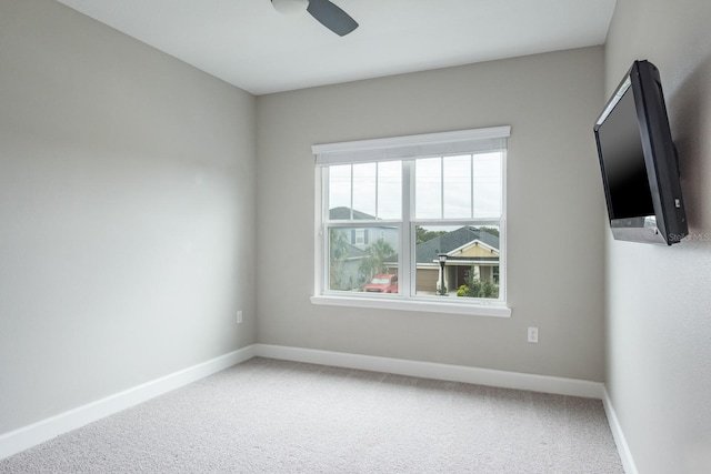 empty room with plenty of natural light, carpet floors, and ceiling fan