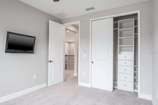 unfurnished bedroom featuring a closet and light carpet