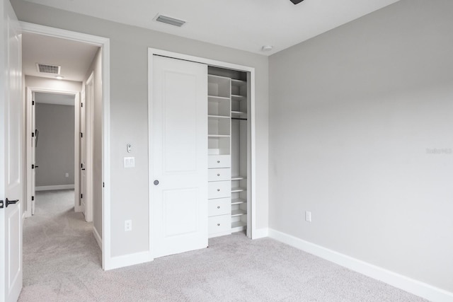 unfurnished bedroom with light carpet and a closet